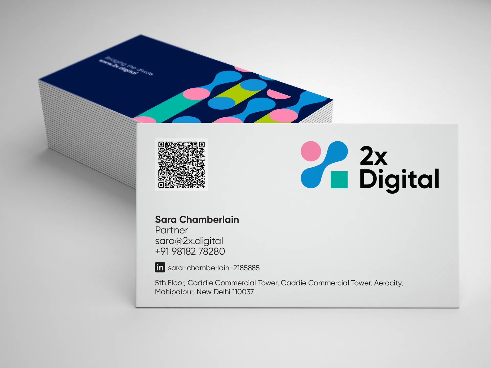 2X Digital business cards with colorful chromosome-inspired logo design on white and navy blue backgrounds