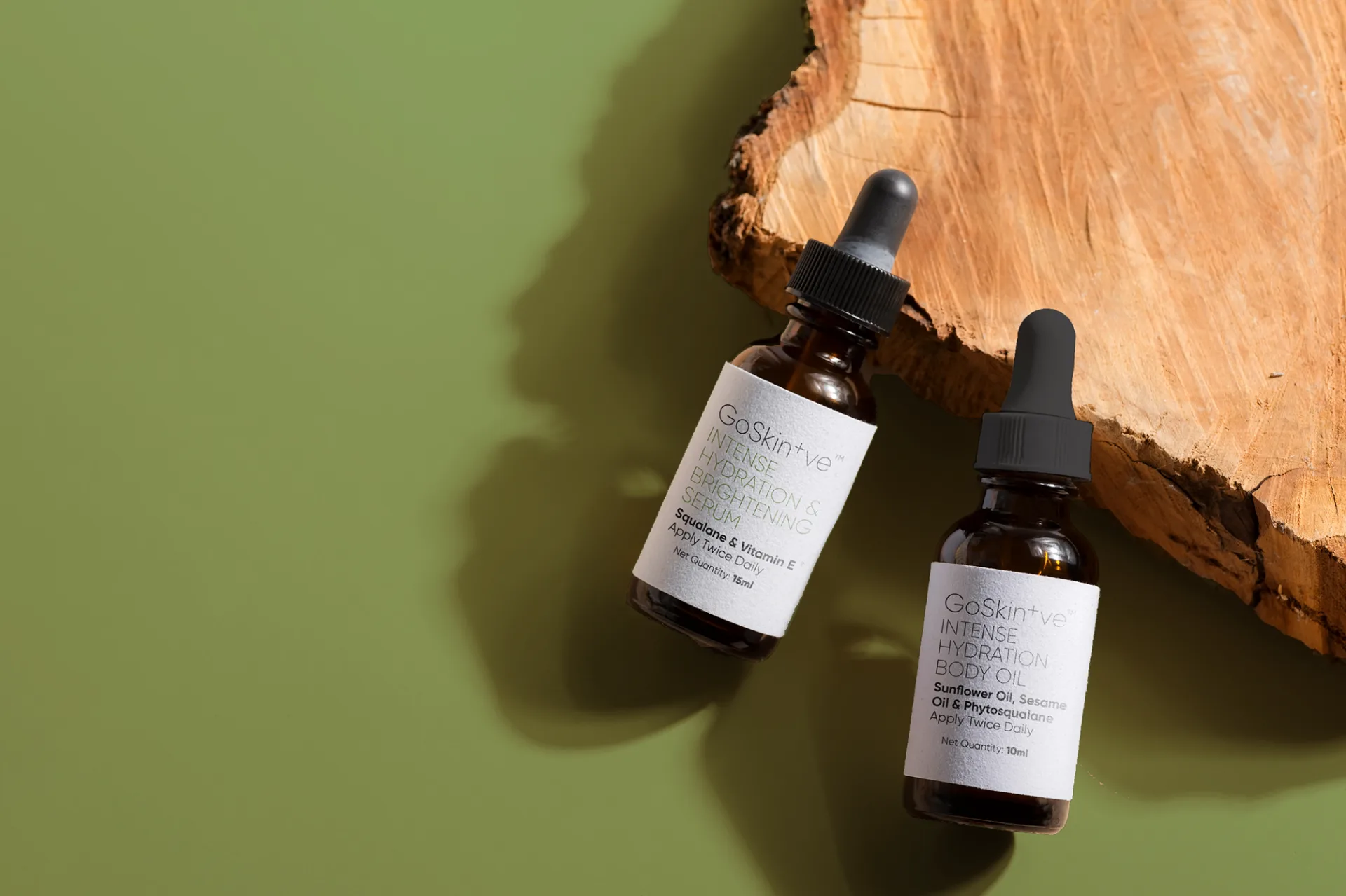 GoSkin+ve serums on natural wooden surface with green background highlighting organic mindful skincare ingredients