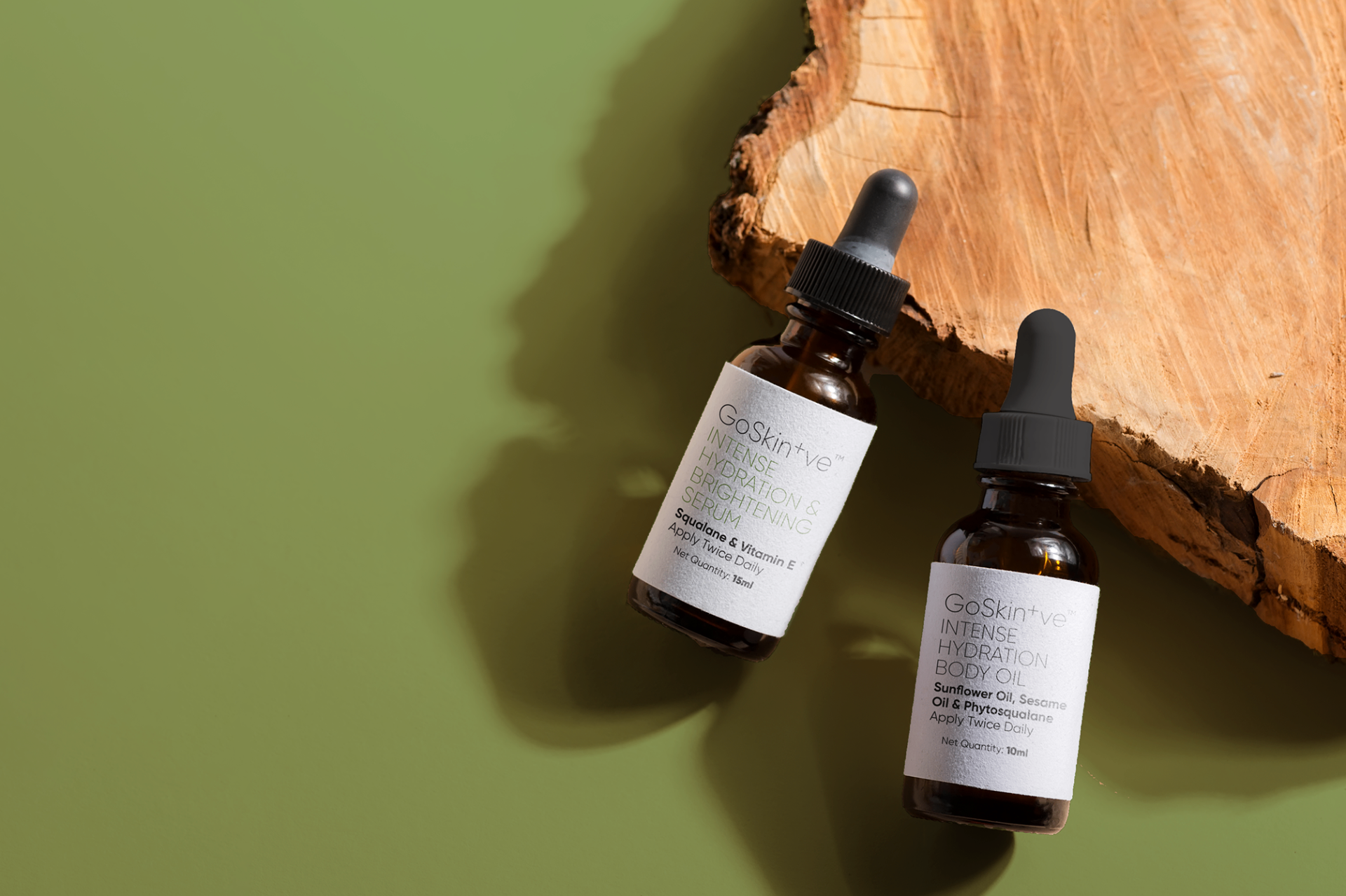GoSkin+ve serums on natural wooden surface with green background highlighting organic mindful skincare ingredients