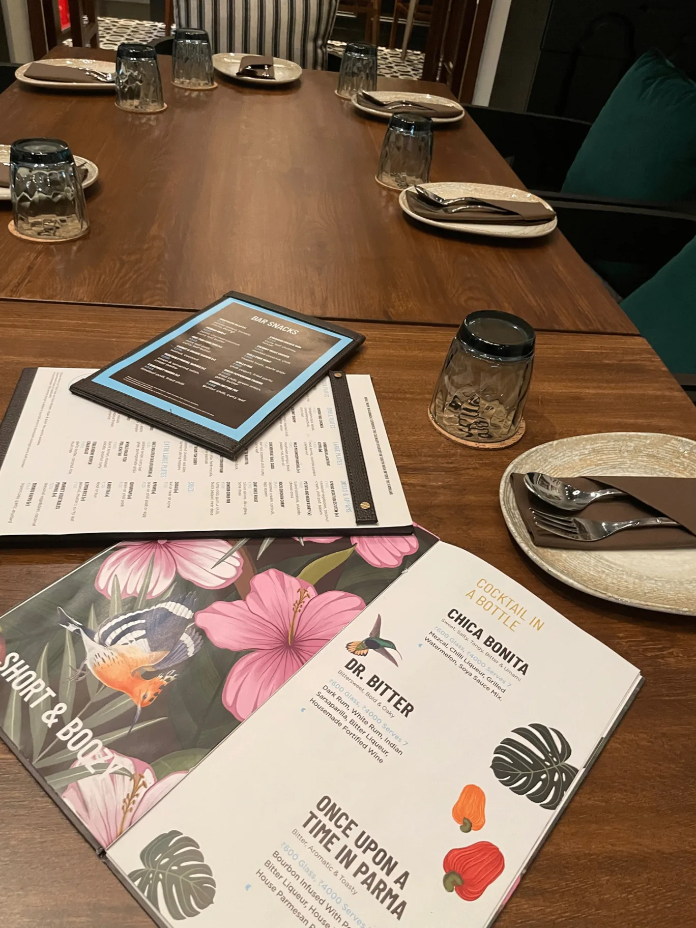 HOSA GOA - Restaurant table setting with botanical cocktail menus and branded materials