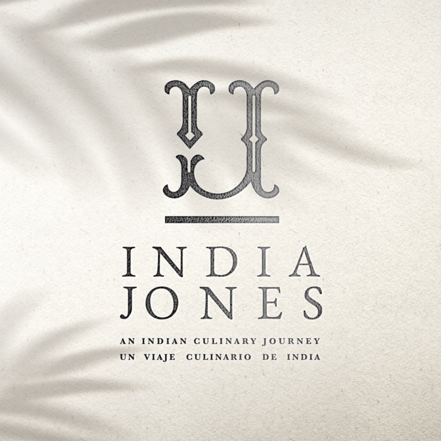 India Jones - Embossed black logo design on textured surface