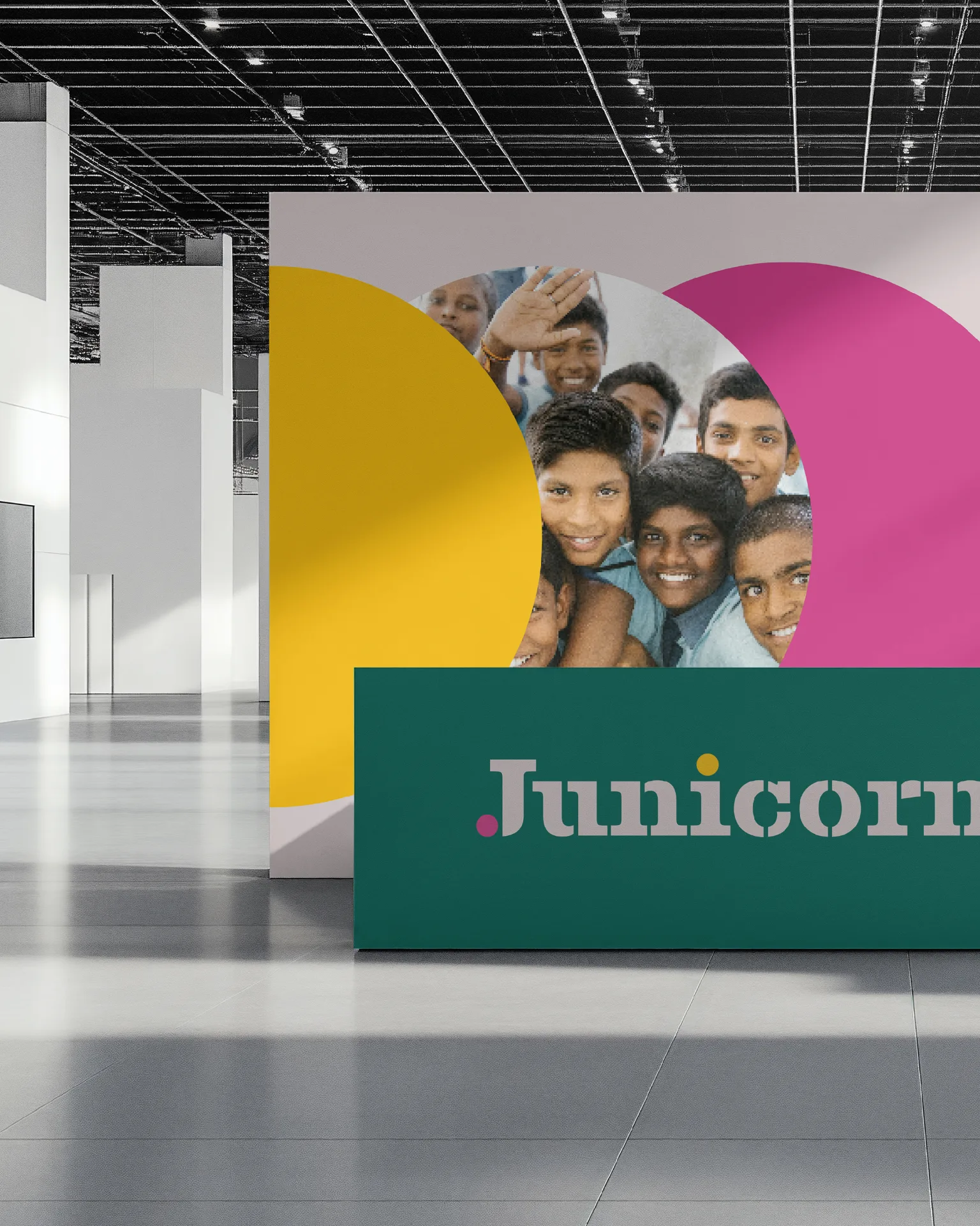 JUNICORN - Exhibition display with colorful brand elements featuring children from rural India