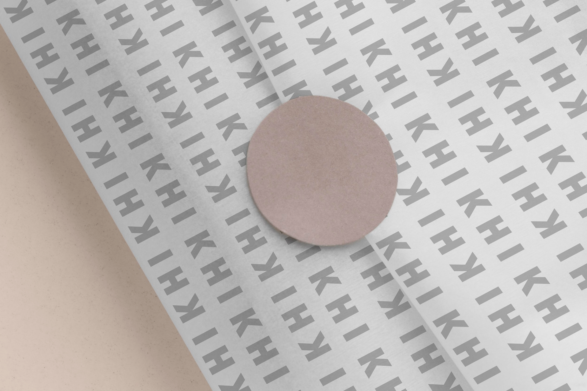 KHI KHI branded pattern paper with repeating logo design in gray tones, showcasing wrapping and packaging applications