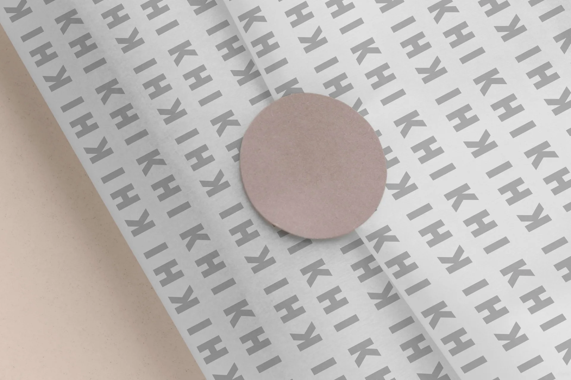 KHI KHI branded pattern paper with repeating logo design in gray tones, showcasing wrapping and packaging applications