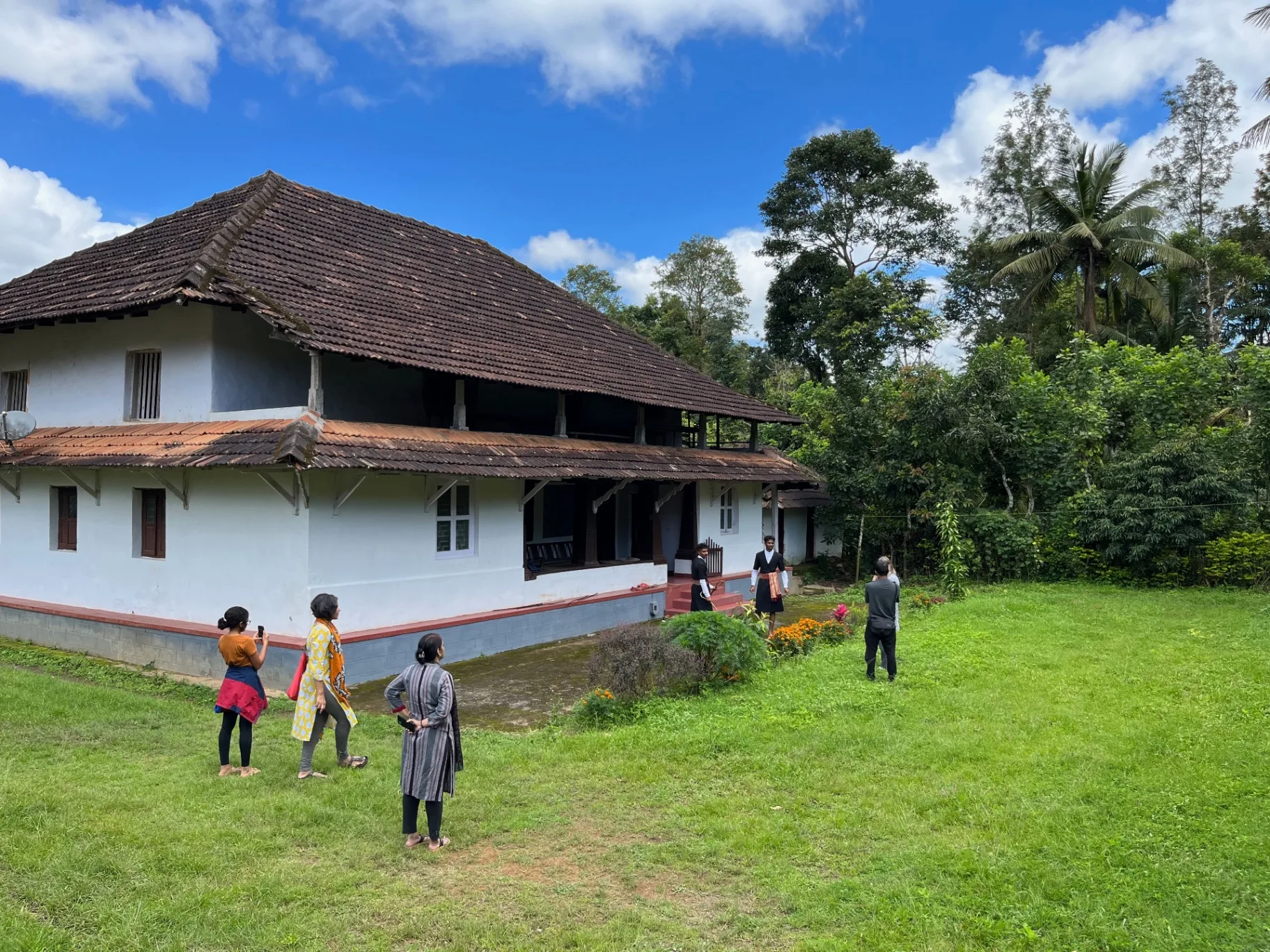 Traditional Kodava house exterior with research team