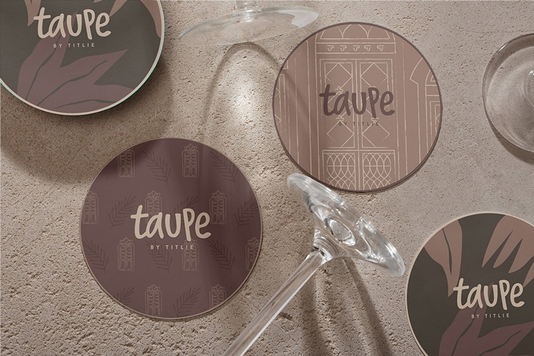 TAUPE branded coasters collection showcasing various design patterns including botanical leaves, Portuguese doors, and brand logo variations
