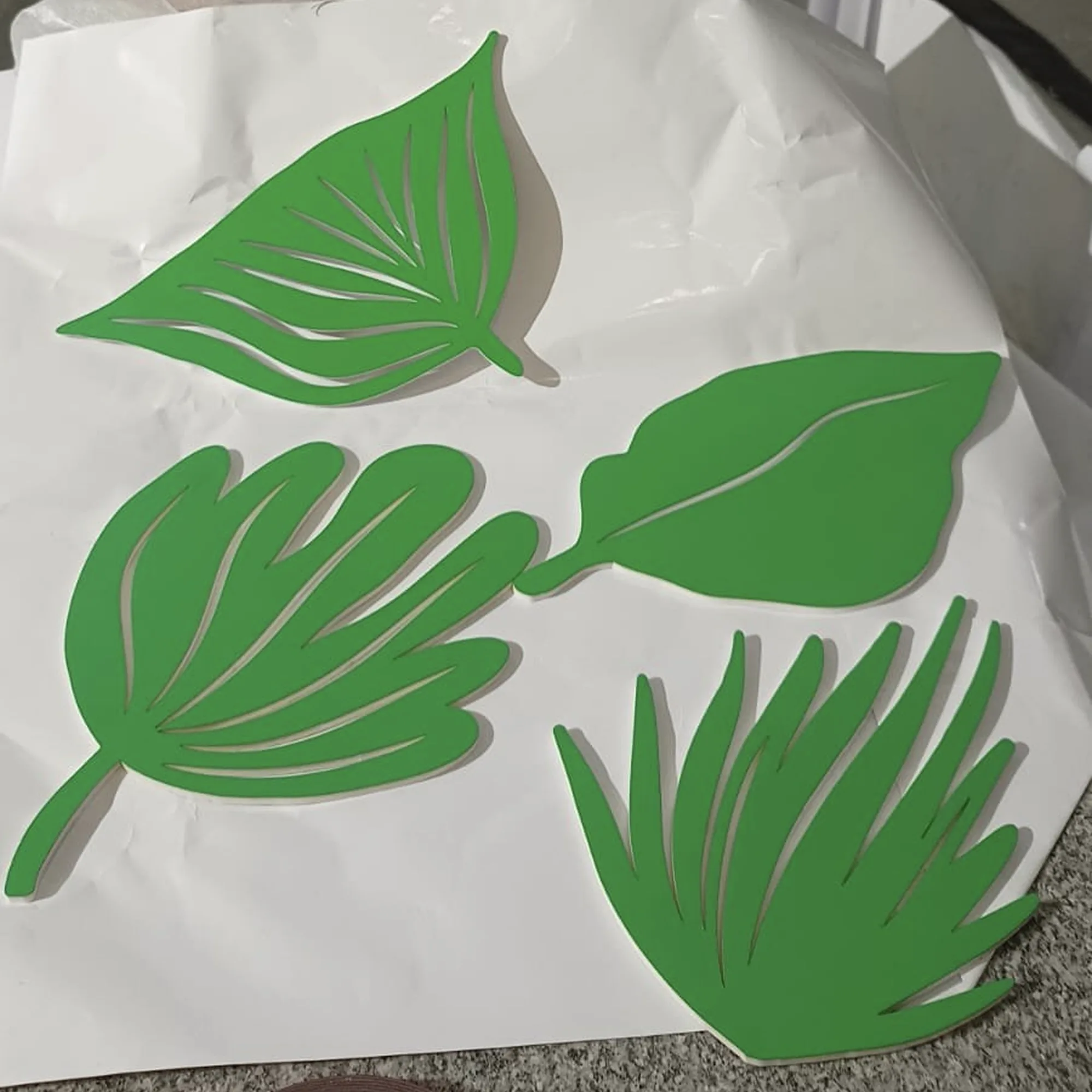 Green botanical leaf cutout patterns and design elements showcasing the Travelling Plants visual identity system